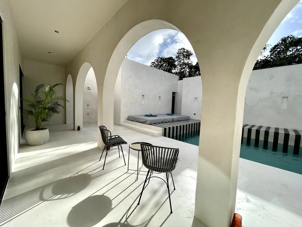 Casa Bali suite principal con cama king y vistas al jardín tropical en Tulum